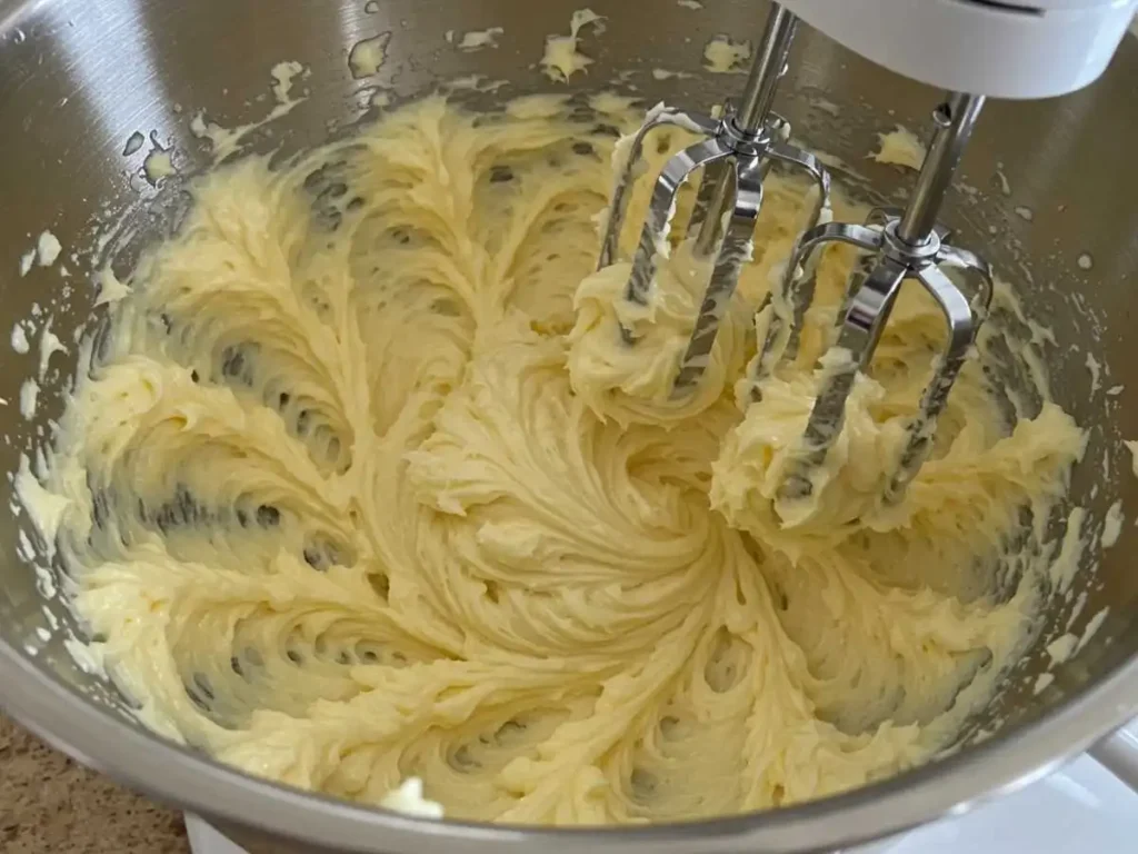 Mantequilla y azúcar cremándose en un bol con batidora eléctrica